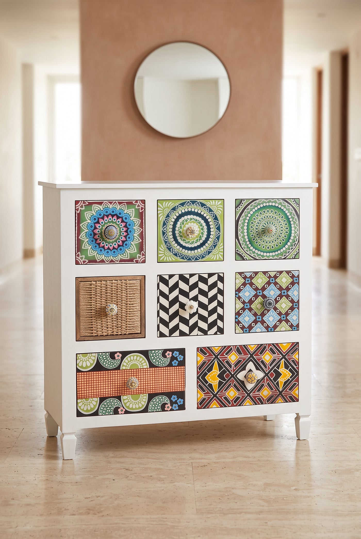 Tile print chest of drawers in a hallway below a round mirror