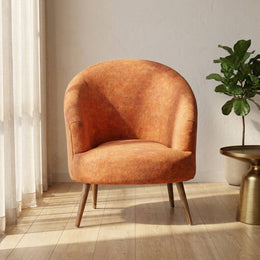 Rust orange barrel accent chair in a styled living room
