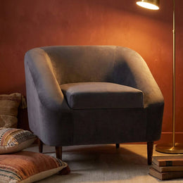 Charcoal velvet lounge chair styled with cushions