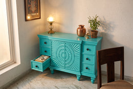 Turquoise sideboard with a drawer open showing storage space
