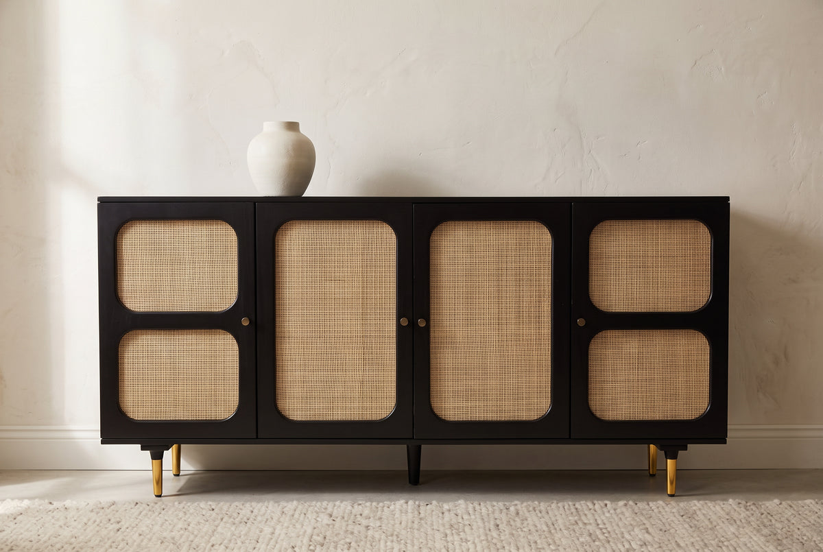 Black and cane four door sideboard with brass legs in a modern room