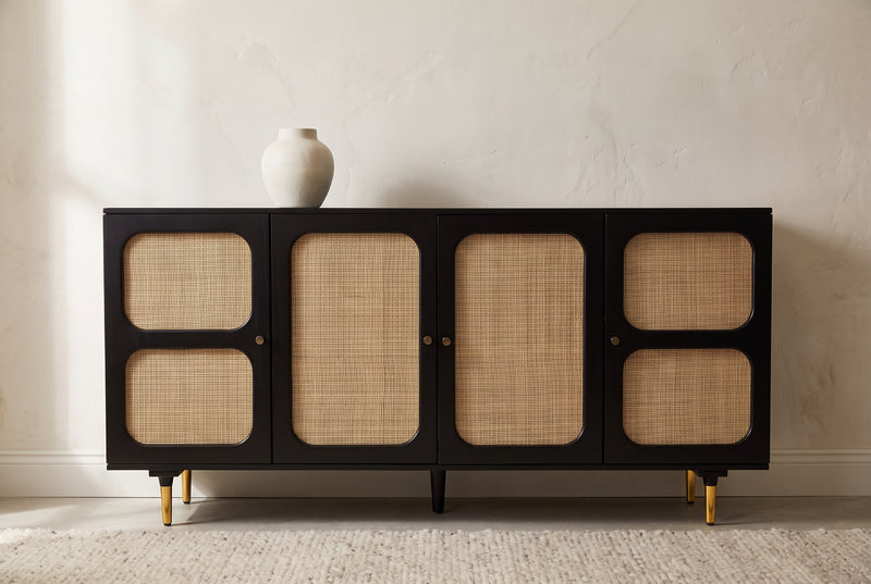 Black and cane four door sideboard with brass legs in a modern room
