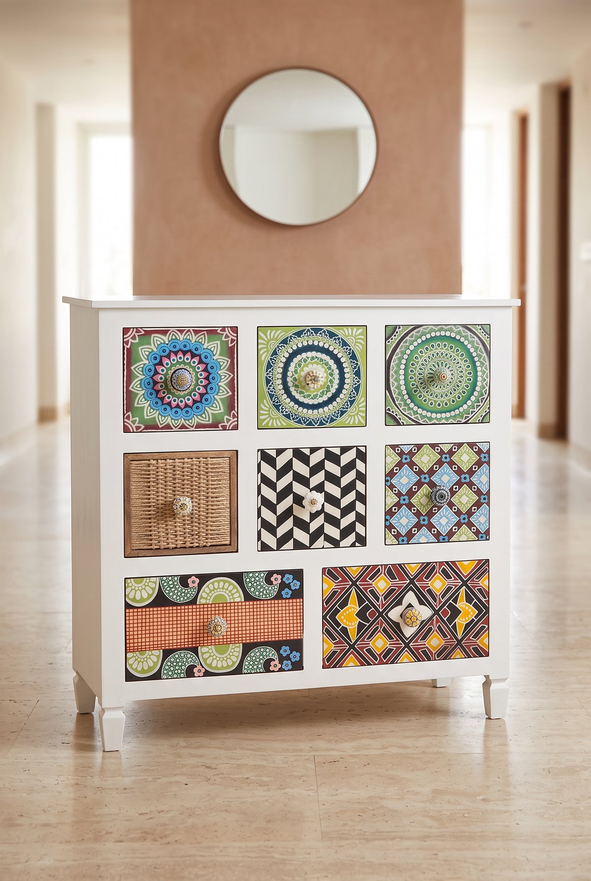 Tile print chest of drawers in a hallway below a round mirror